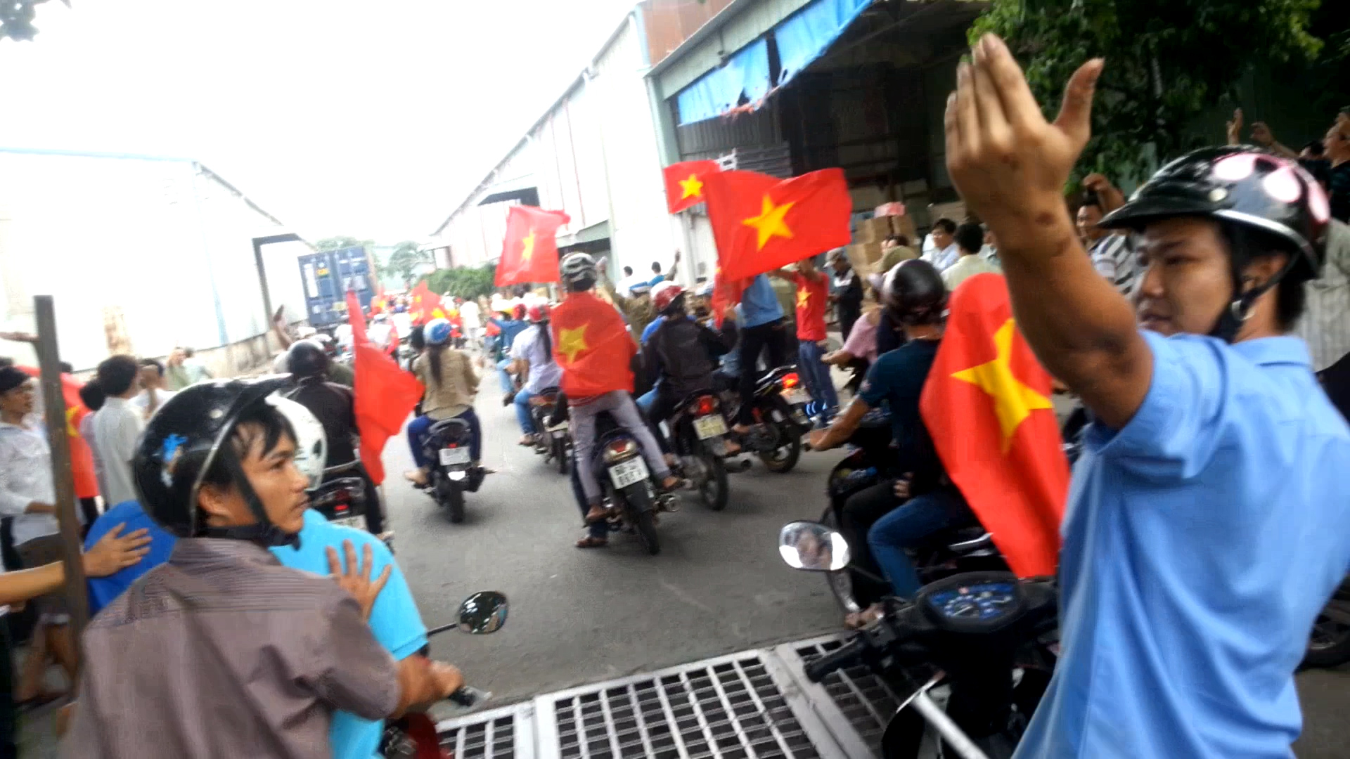 Người mặc áo xanh công nhân, ra lệnh với vẻ oai vệ cho các "phụ tá" tiến vào